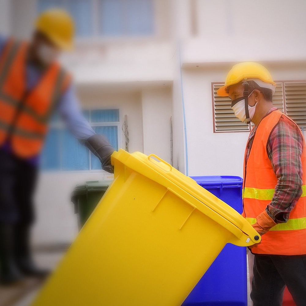 Zwei Arbeiter leeren eine Abfalltonne