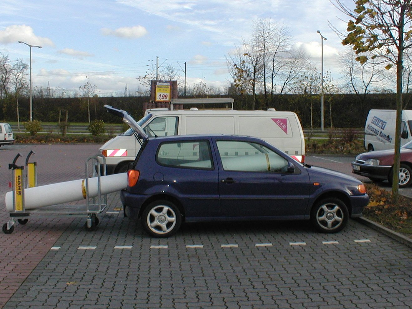 Ein Auto mit weit aus dem Kofferraum herausragender Rolle Teppichboden