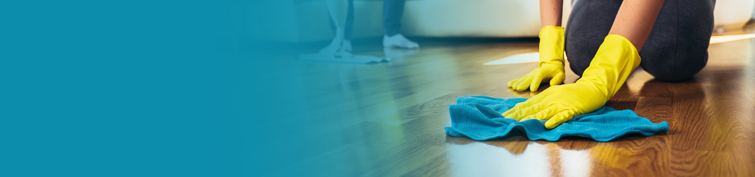 Nahaufnahme von Händen mit Gummihandschuhen beim Putzen