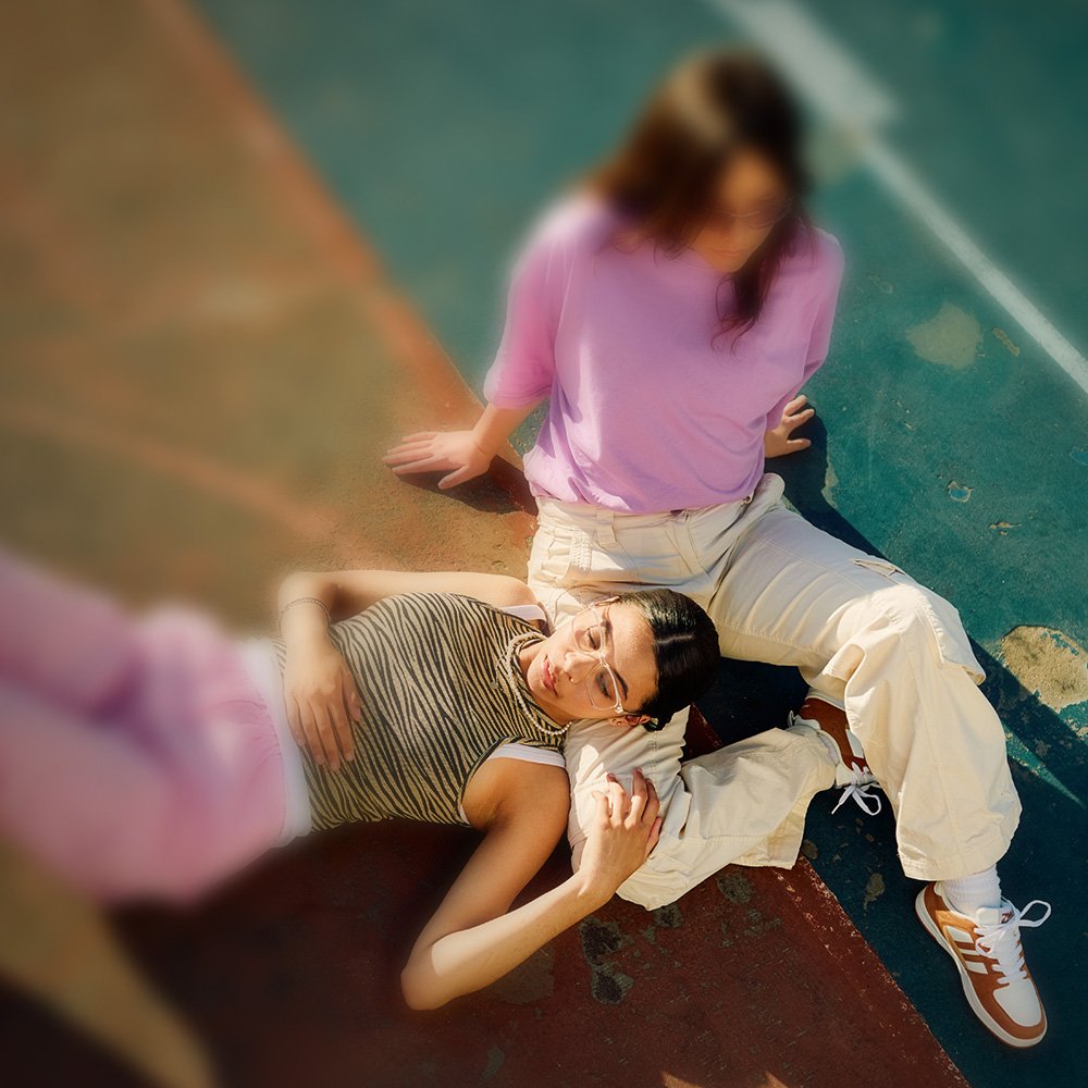 Zwei junge Frauen liegen entspannt auf dem Boden