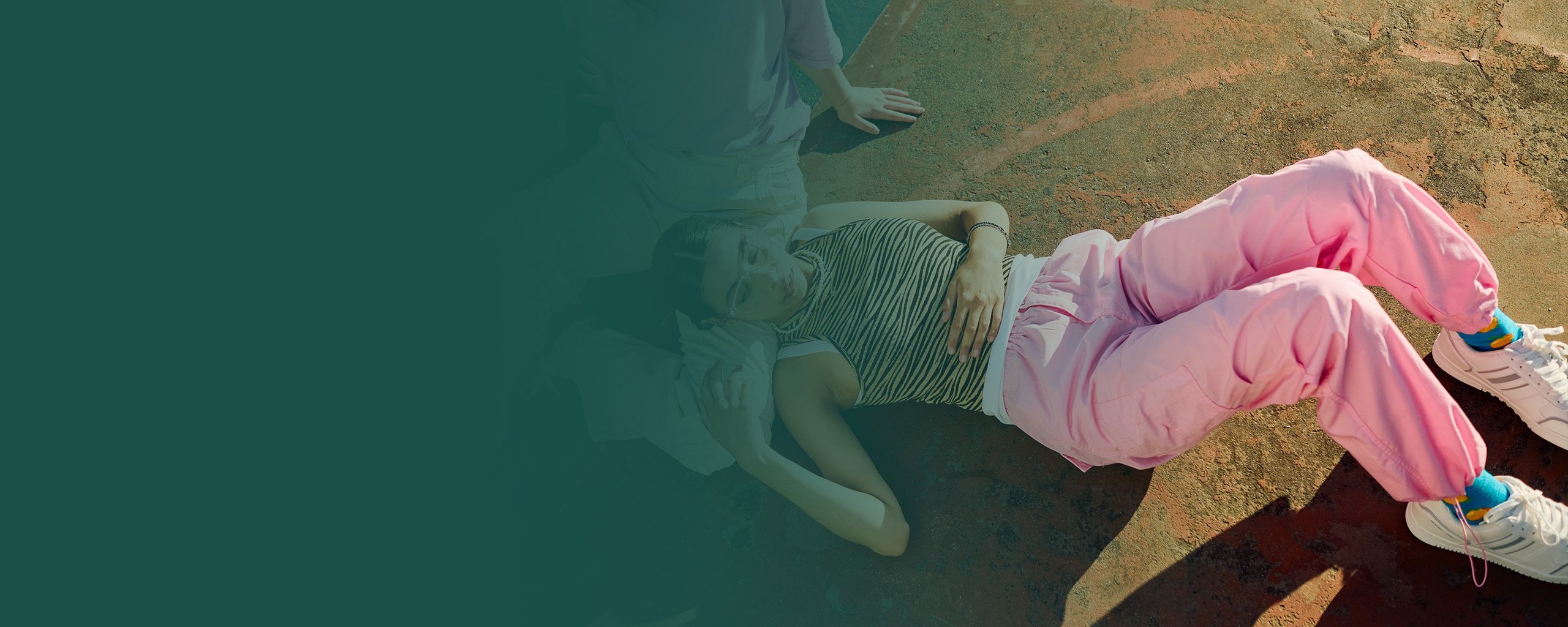 Zwei junge Frauen liegen entspannt auf dem Boden