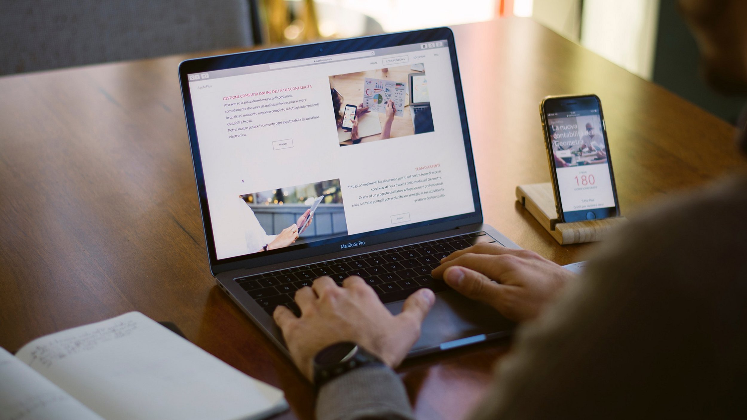 Schulterblick einer Person beim Arbeiten an einem Laptop