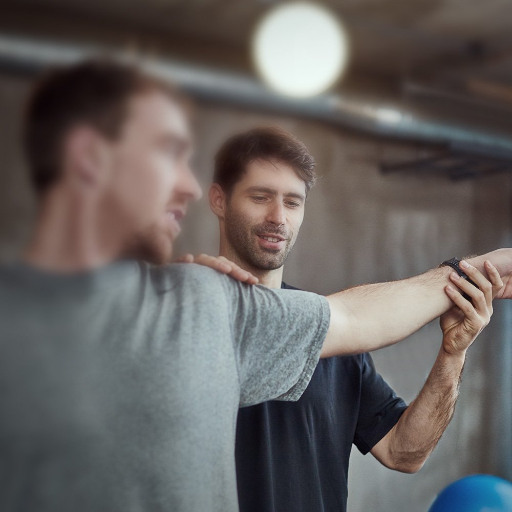 Ein Physiotherapeut behandelt den Arm eines Patienten