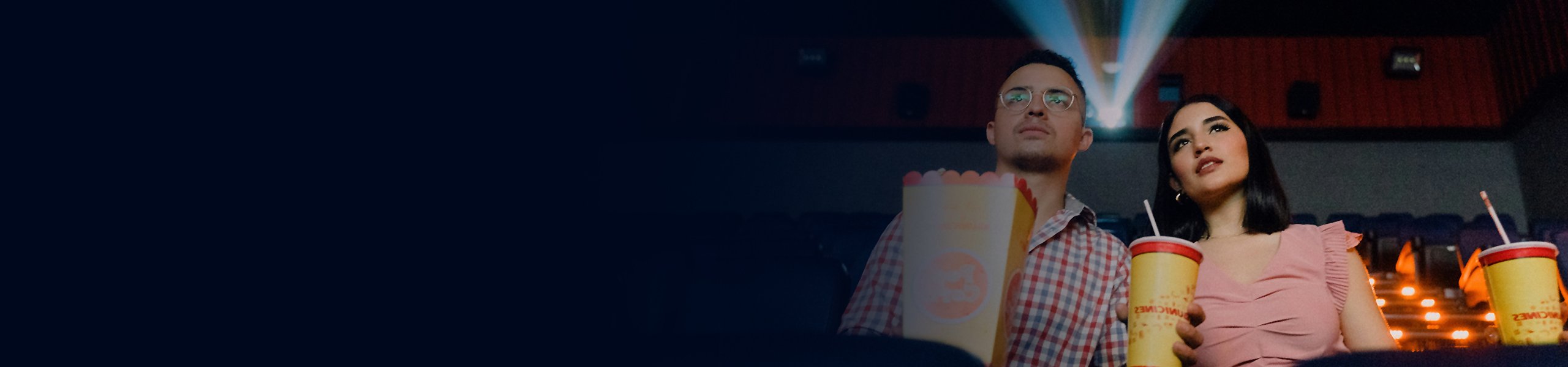 Zwei Menschen im Kino mit Popcorn und Getränken